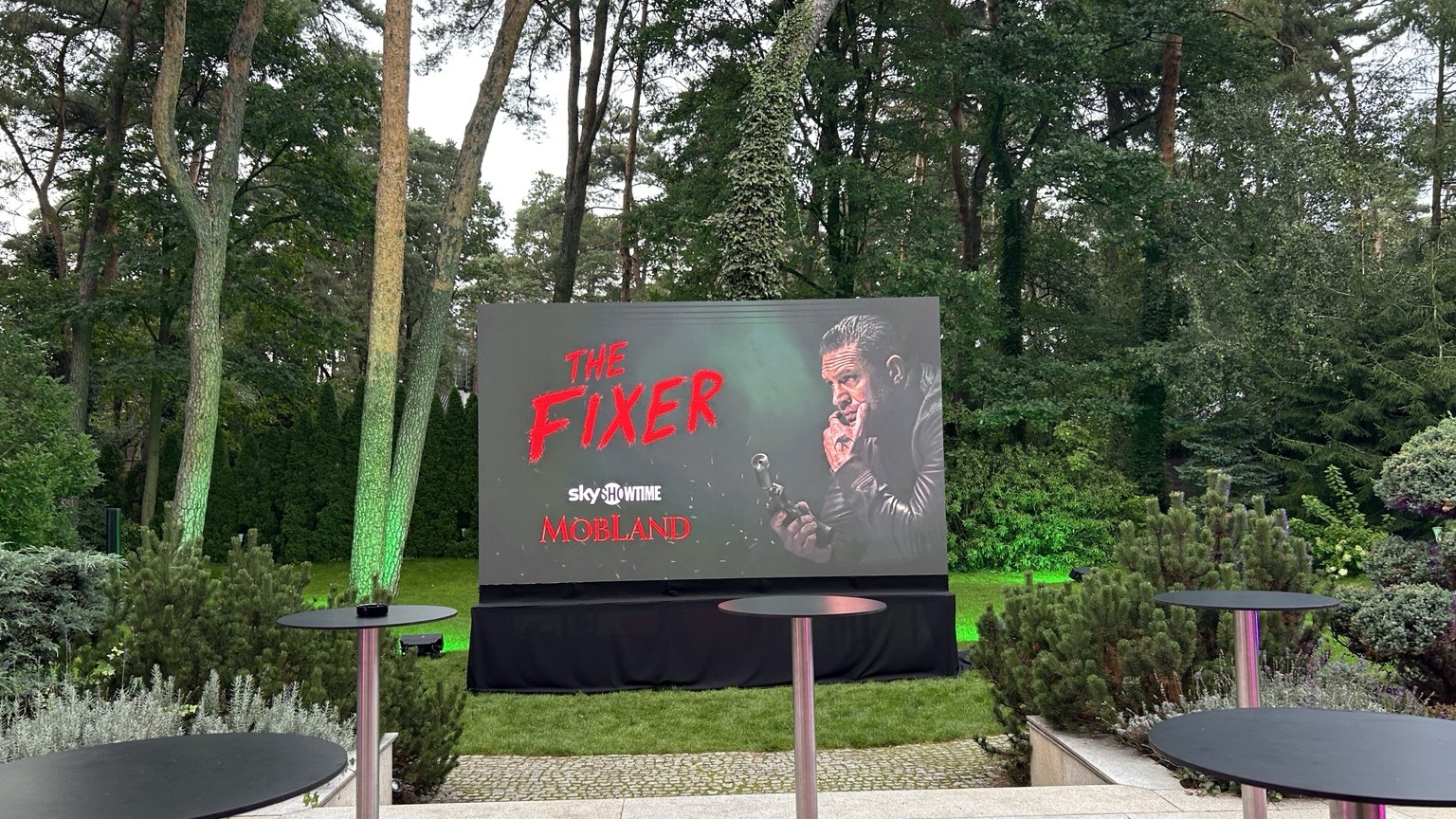 Promotional screen surrounded by greenery