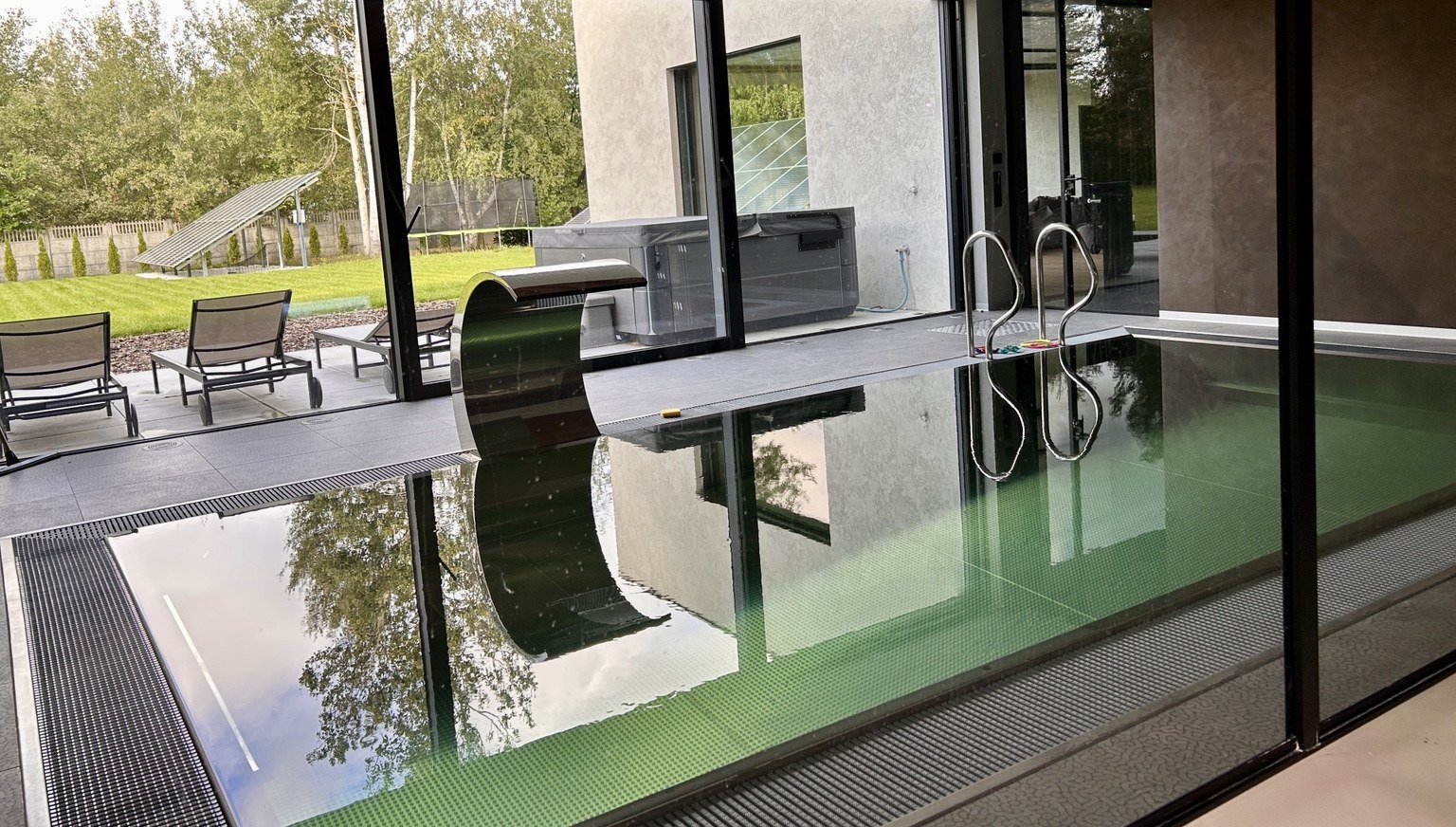 Indoor pool with a view through the glazing onto the garden