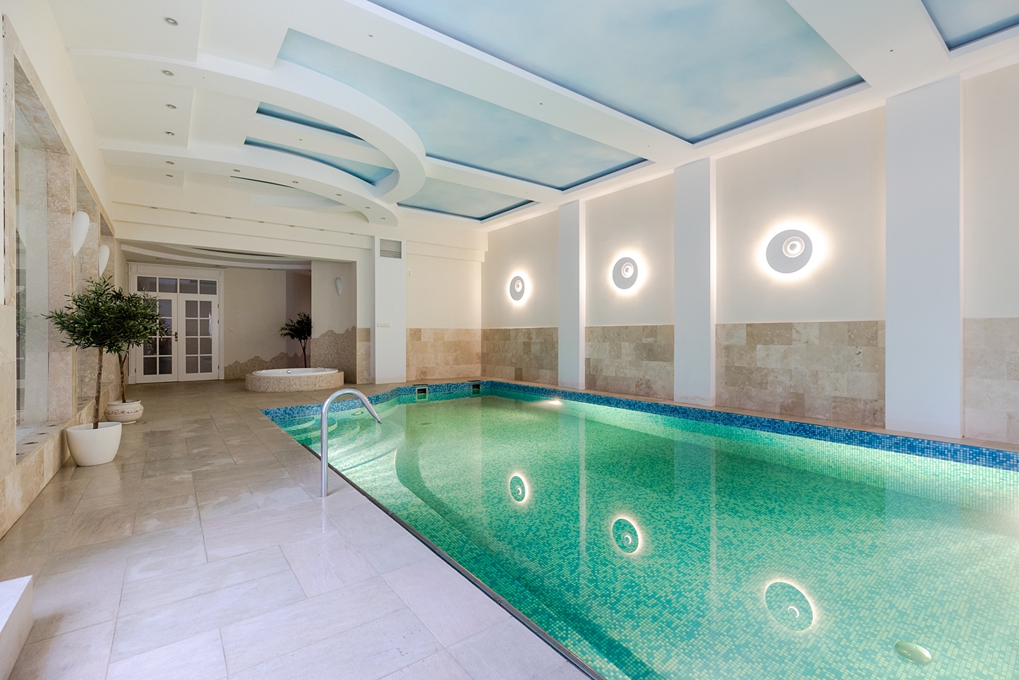 Bright indoor pool with soft blue ceiling details
