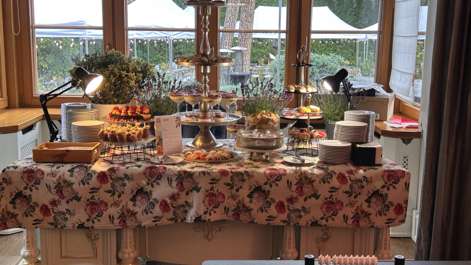 Breakfast and dessert buffet arranged beside garden windows