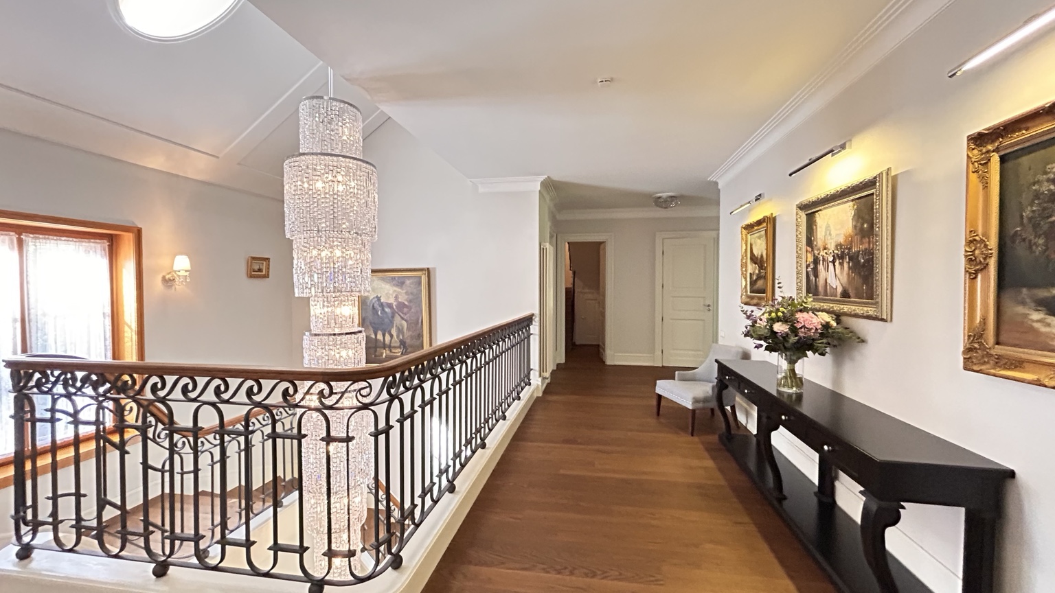 Elegant upper hall with a chandelier and framed artwork