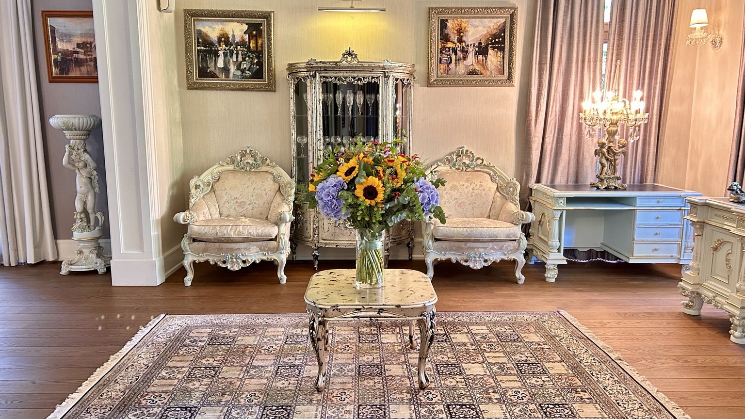 Classic sitting room with flowers and ornate armchairs