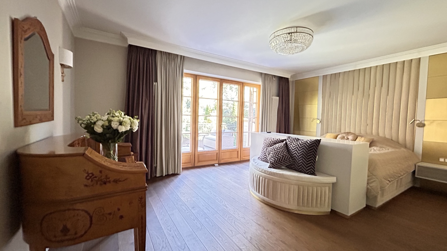 Spacious bedroom with a sitting area and balcony doors