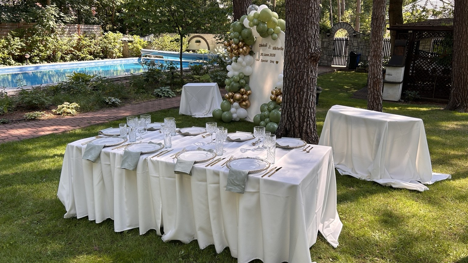 White decorations and tables prepared for a garden celebration