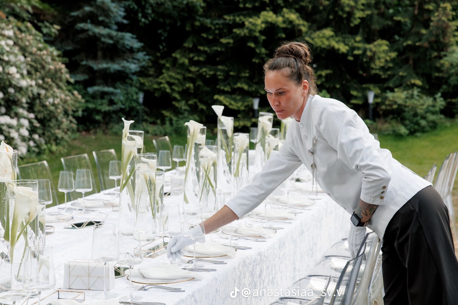 Elegant table being prepared for an outdoor celebration