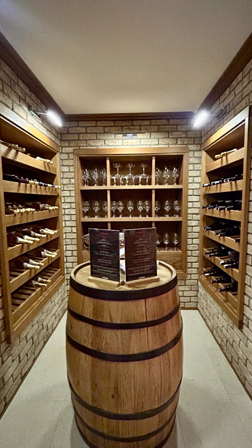 Elegant wine cellar with glassware and wooden wine racks
